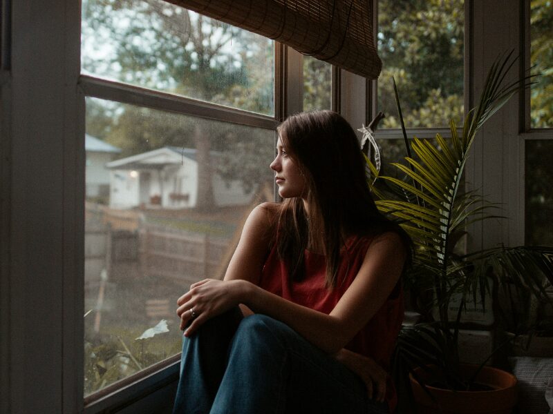 Mulher sozinha e pensativa representando os efeitos de um relacionamento abusivo